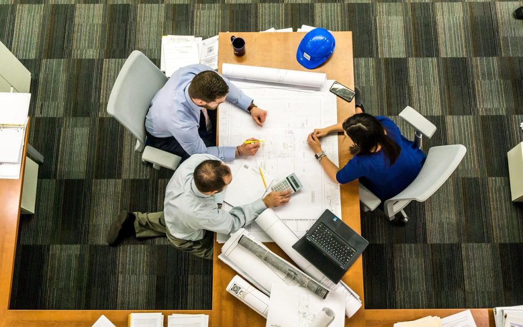 Two people working across a shared desk