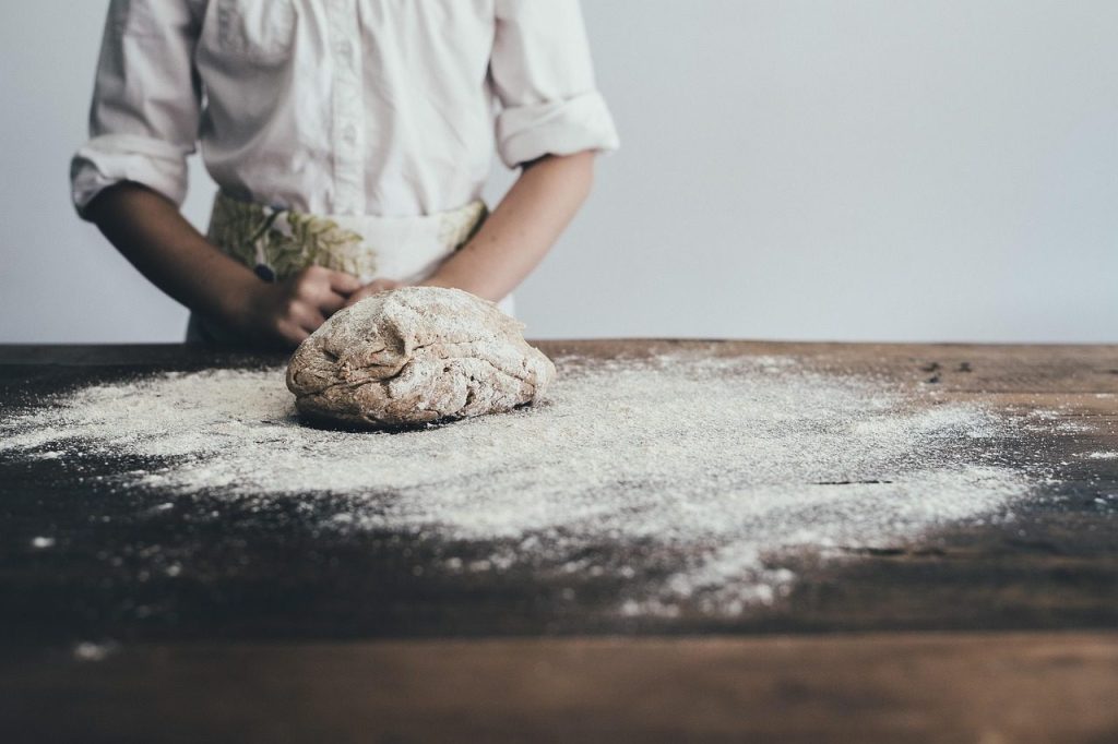 Shaping dough on a floured bench