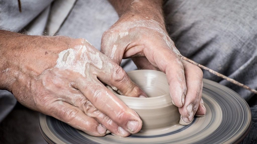 Hands centring a pot on the wheel