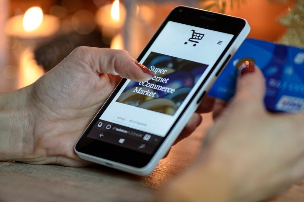 Paying by card on a phone, one hand each