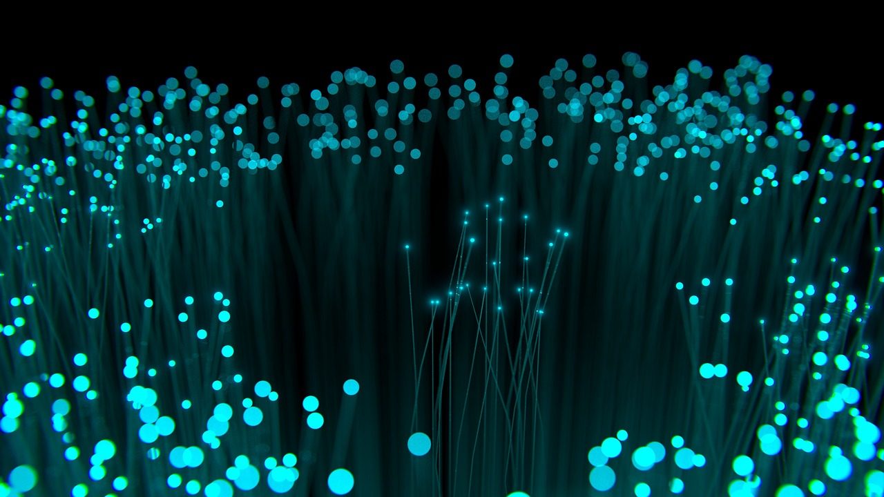 Optical fibres glowing cyan against a black ground