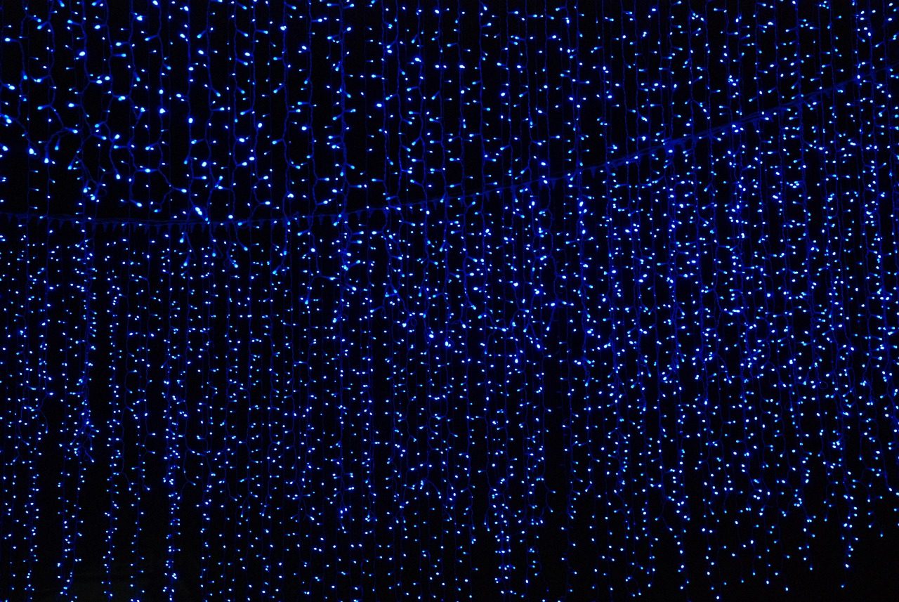 A hanging curtain of small blue lights in darkness